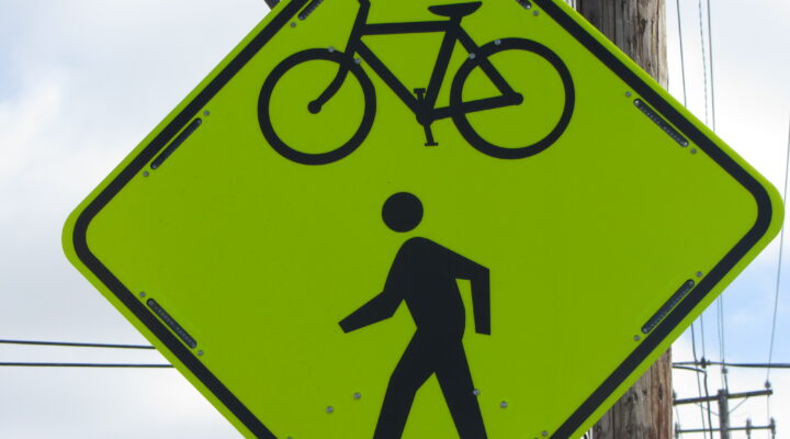 A reflective road sign shows a bicycle icon and a pedestrian icon