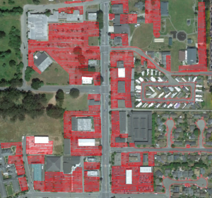 A satellite image of the McKinleyville Town Center with extensive parking areas highlighted in red.